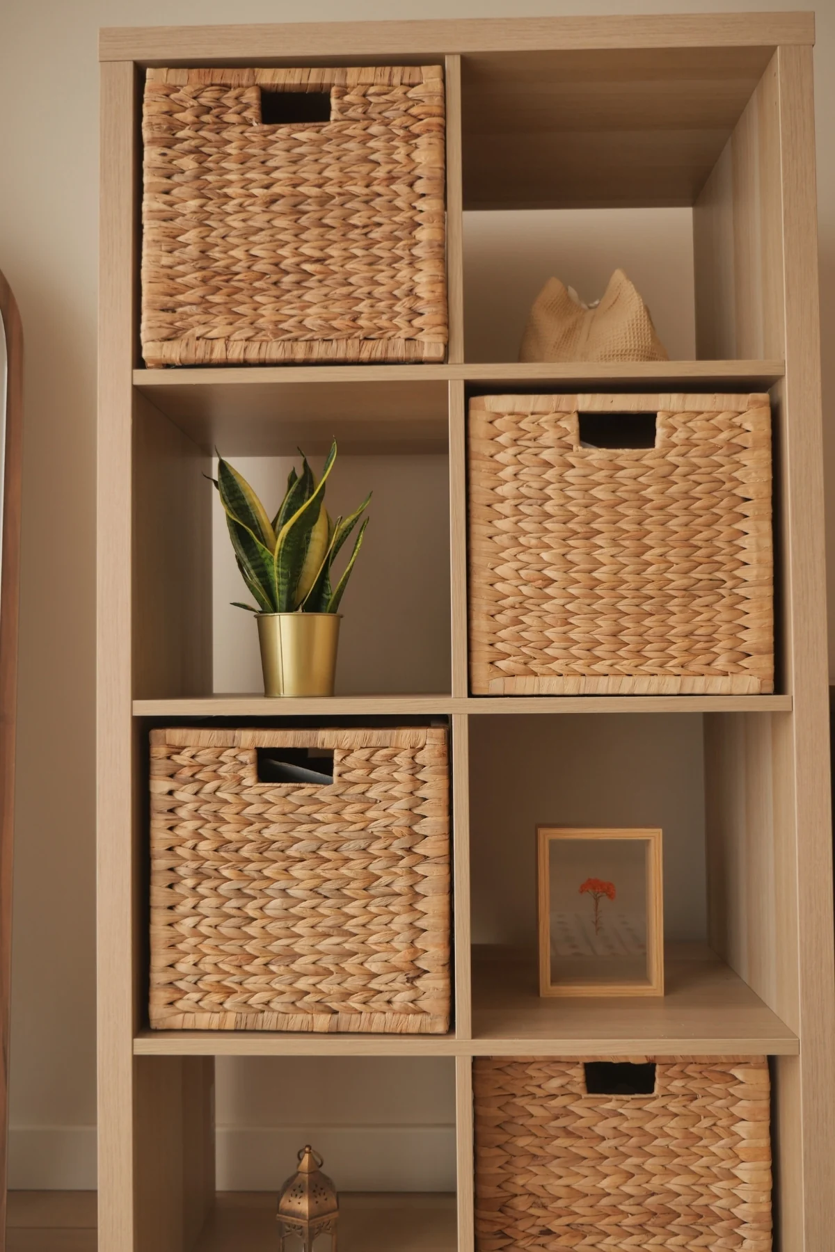 A white cube shelf holding fabric storage baskets