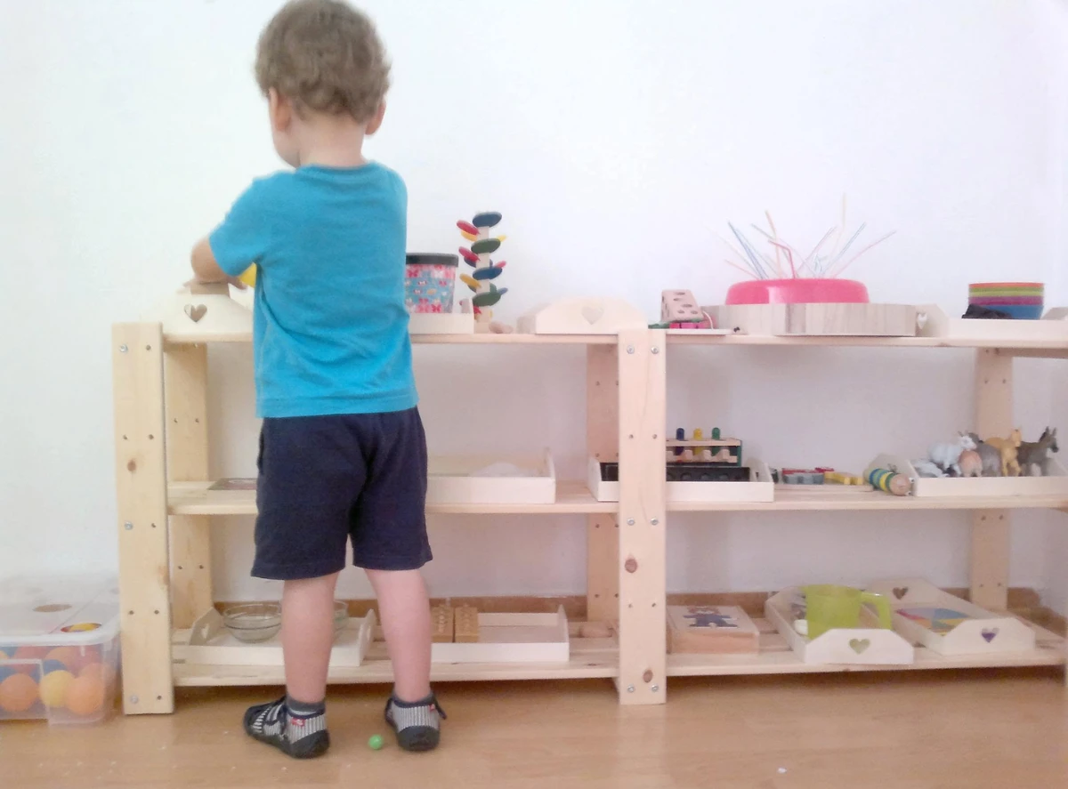 Miri took a photo of her son Will playing with toys on his toy shelf.
