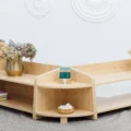 Montessori at home, started small: a low wooden shelf with a few toys and a basket beside a soft rug
