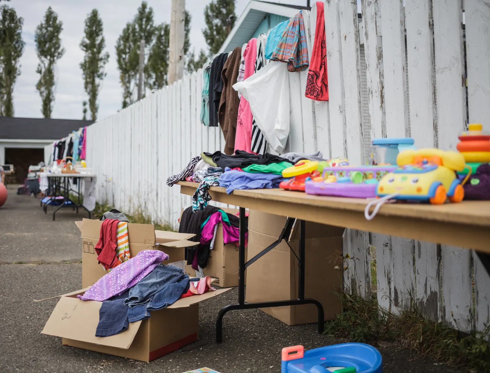 Used wooden toys and children's books laid out on a table at a yard sale