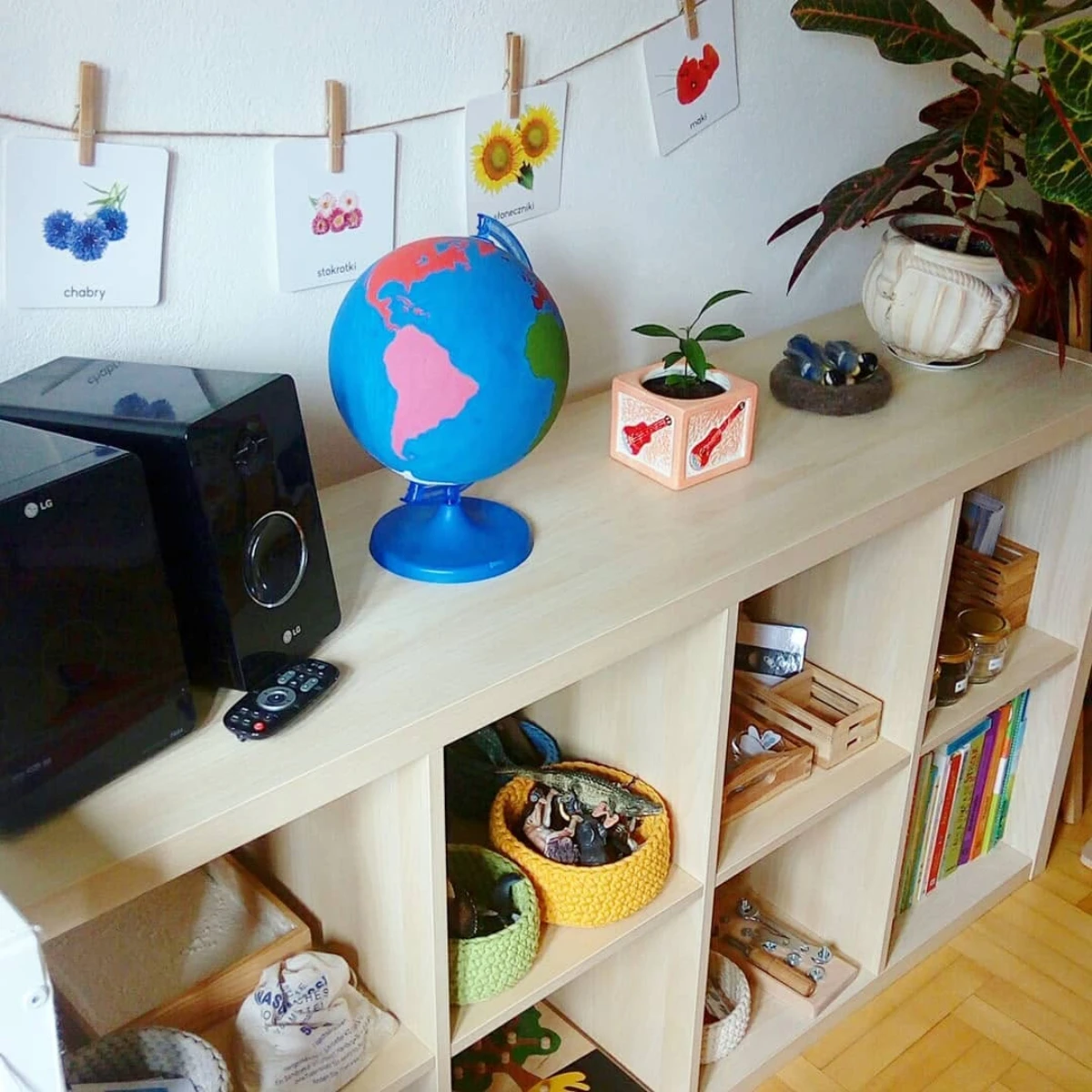 A low wooden shelf with a few toys set out for a three-year-old