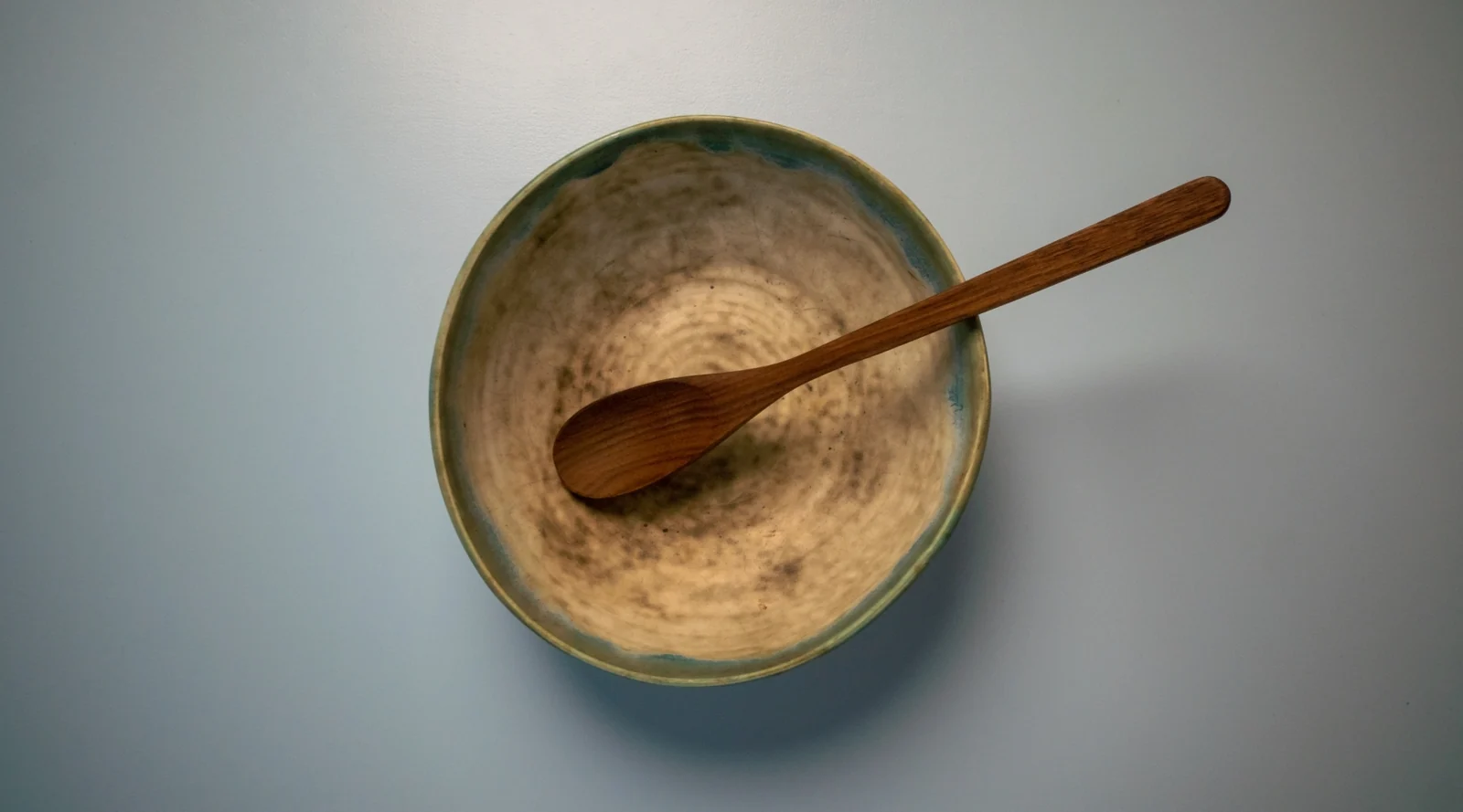 Wooden spoon resting in a ceramic bowl, seen from above